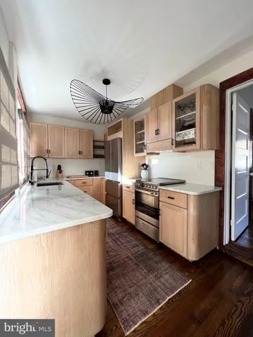 a large kitchen with stainless steel appliances granite countertop a lot of counter space and wooden floors