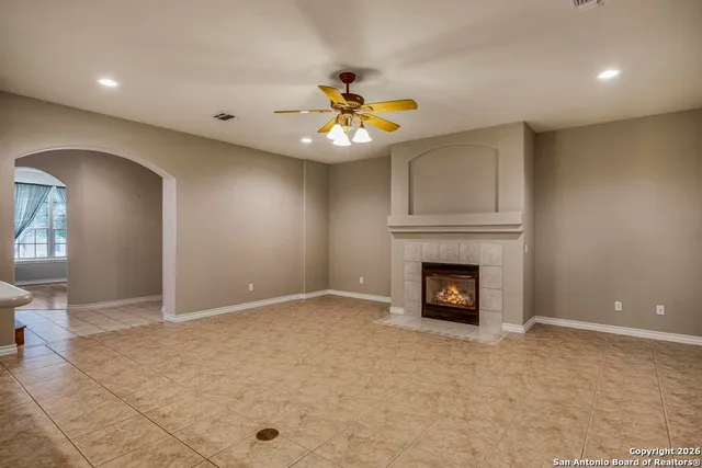 an empty room with fireplace and fan