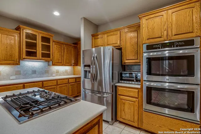 a kitchen with granite countertop stainless steel appliances and wooden cabinets