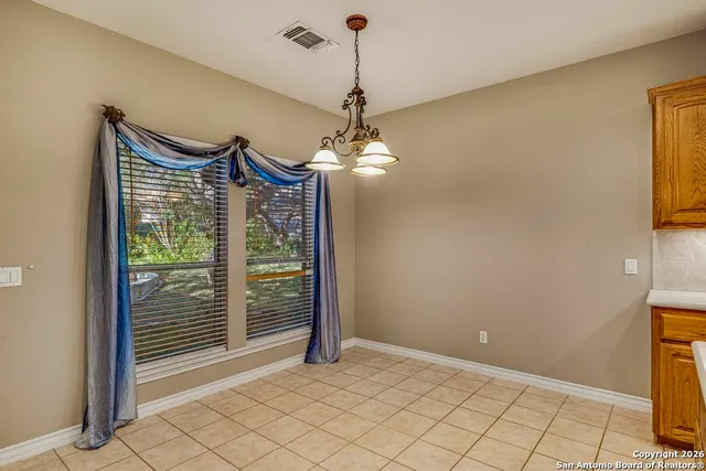 a view of a room with wooden floor chandeliers and kitchen
