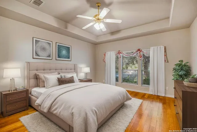 a spacious bedroom with a large bed and a chandelier