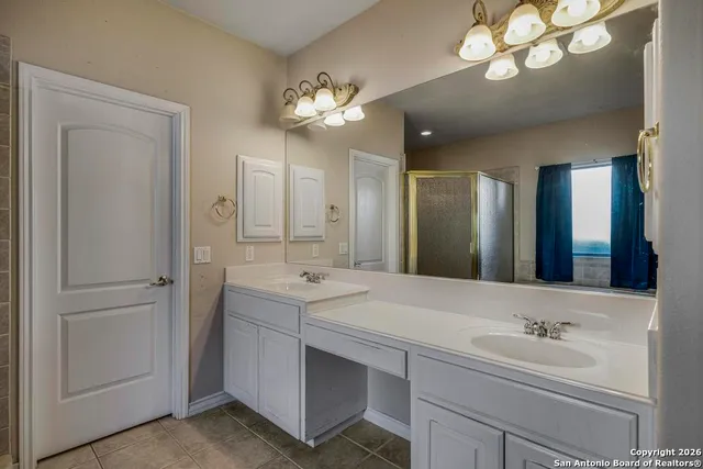 a bathroom with a sink a large mirror and a light fixture