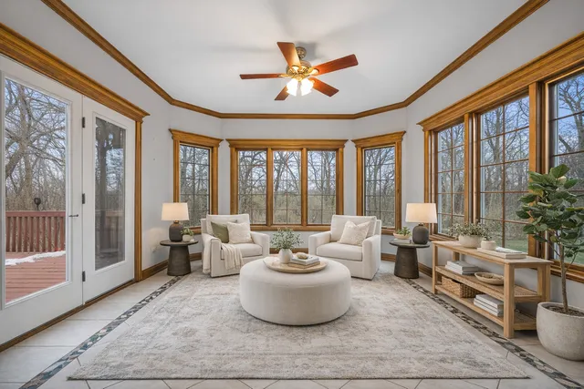 an empty room with ceiling fan and windows