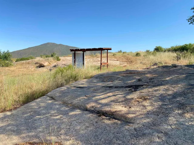 a view of a dry yard with wooden fence