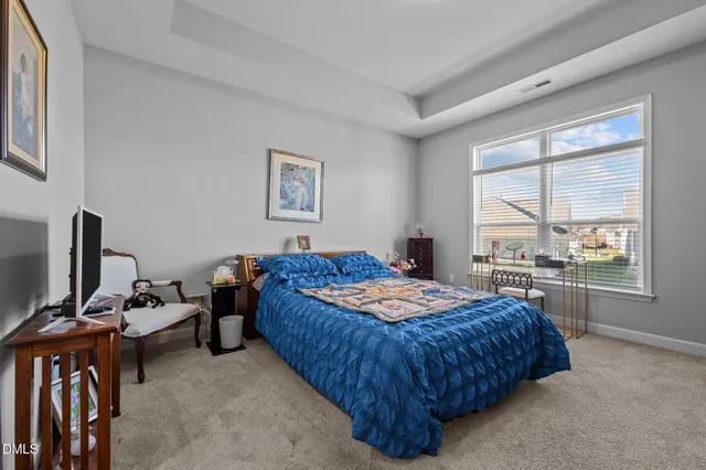 a bedroom with a bed and a flat tv screen on the dresser
