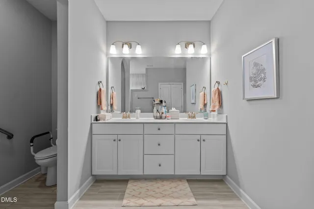 a bathroom with a double vanity sink and a toilet