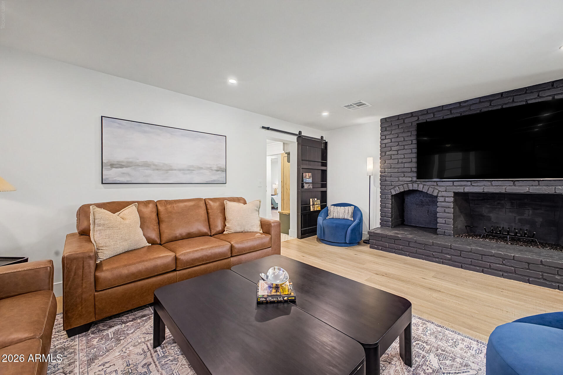 3341 East Cochise Road Phoenix, AZ 85028 - Photo 21 of 46 a living room with furniture a flat screen tv and a fireplace