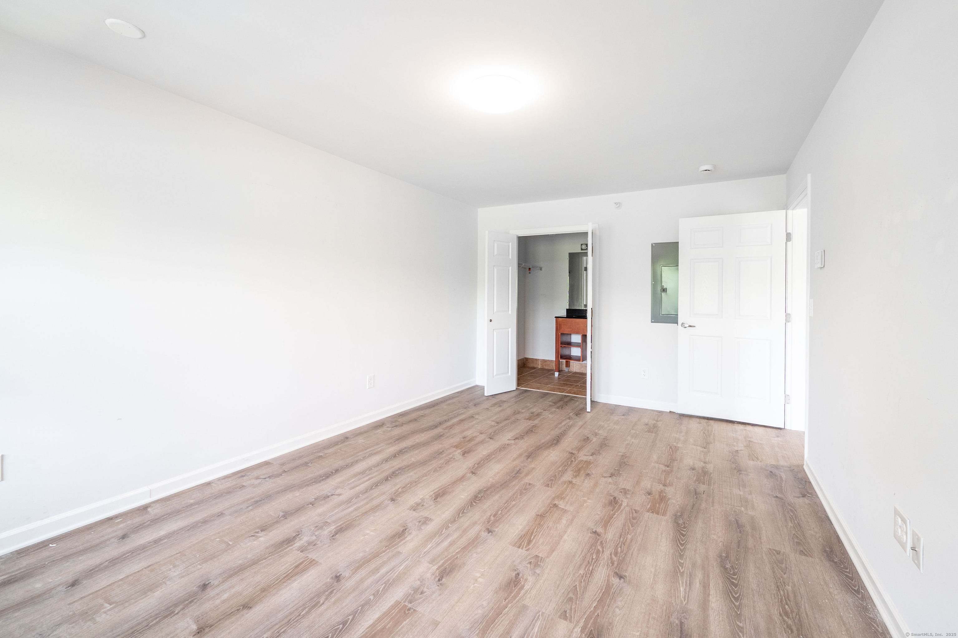 1030 Federal Road, Unit 201 Brookfield, CT 06804 - Photo 8 of 20 an empty room with wooden floor and windows