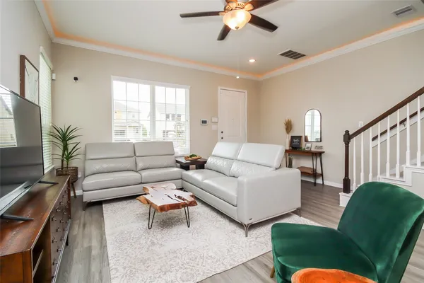 a living room with furniture ceiling fan and a window