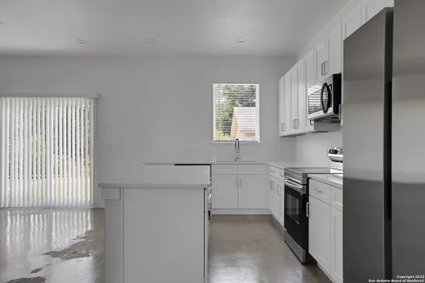 a kitchen with stainless steel appliances granite countertop white cabinets and window
