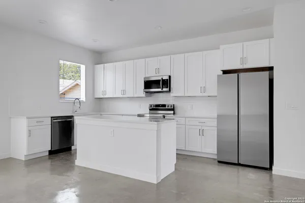 a kitchen with cabinets stainless steel appliances and a window