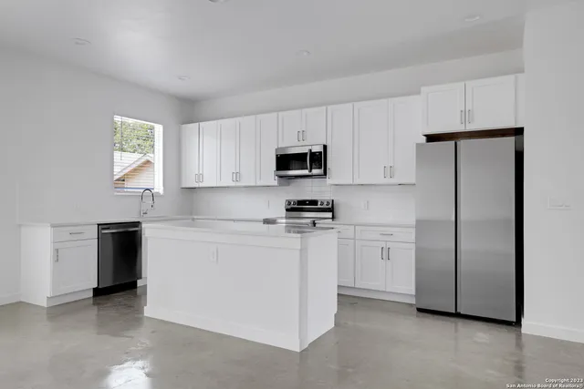 a kitchen with cabinets stainless steel appliances and a window
