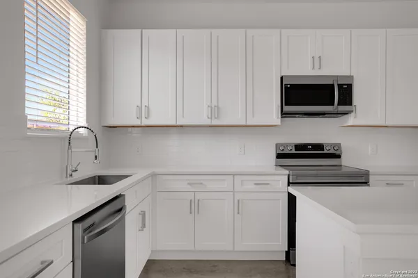 a kitchen with white cabinets and a stove top oven