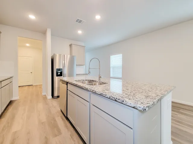 a kitchen with stainless steel appliances granite countertop a sink stove and refrigerator