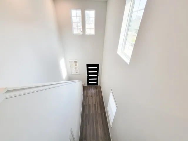 a view of a hallway with wooden floor and staircase