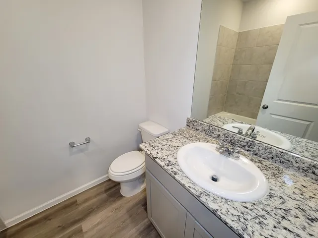 a bathroom with a sink a toilet and a mirror