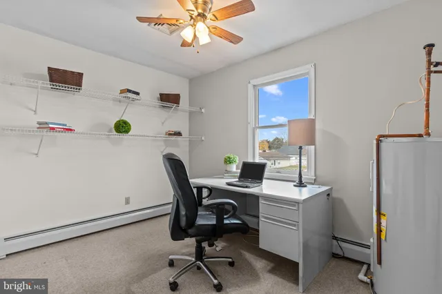 a view of a workspace with furniture and a window