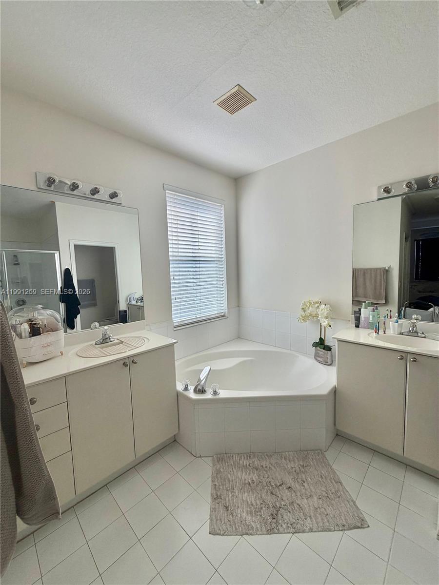 15391 Southwest 17th Terrace Miami, FL 33185 - Photo 13 of 16 a spacious bathroom with a double vanity sink mirror and bathtub