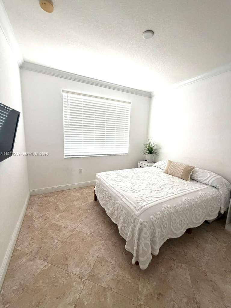 15391 Southwest 17th Terrace Miami, FL 33185 - Photo 8 of 16 a bed sitting in a bedroom next to a window