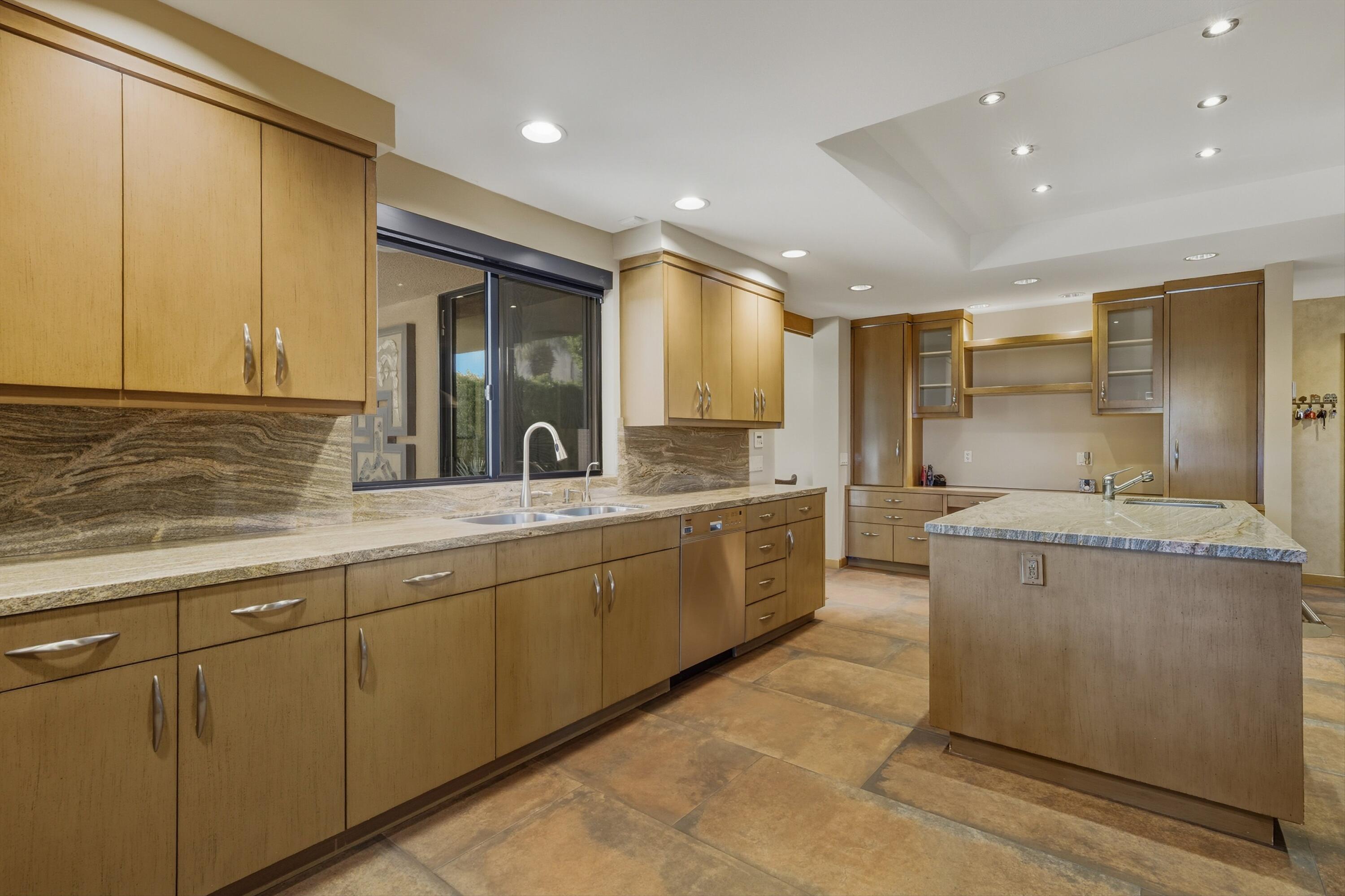 70150 Thunderbird Road Rancho Mirage, CA 92270 - Photo 27 of 67 a large kitchen with stainless steel appliances granite countertop a sink and cabinets