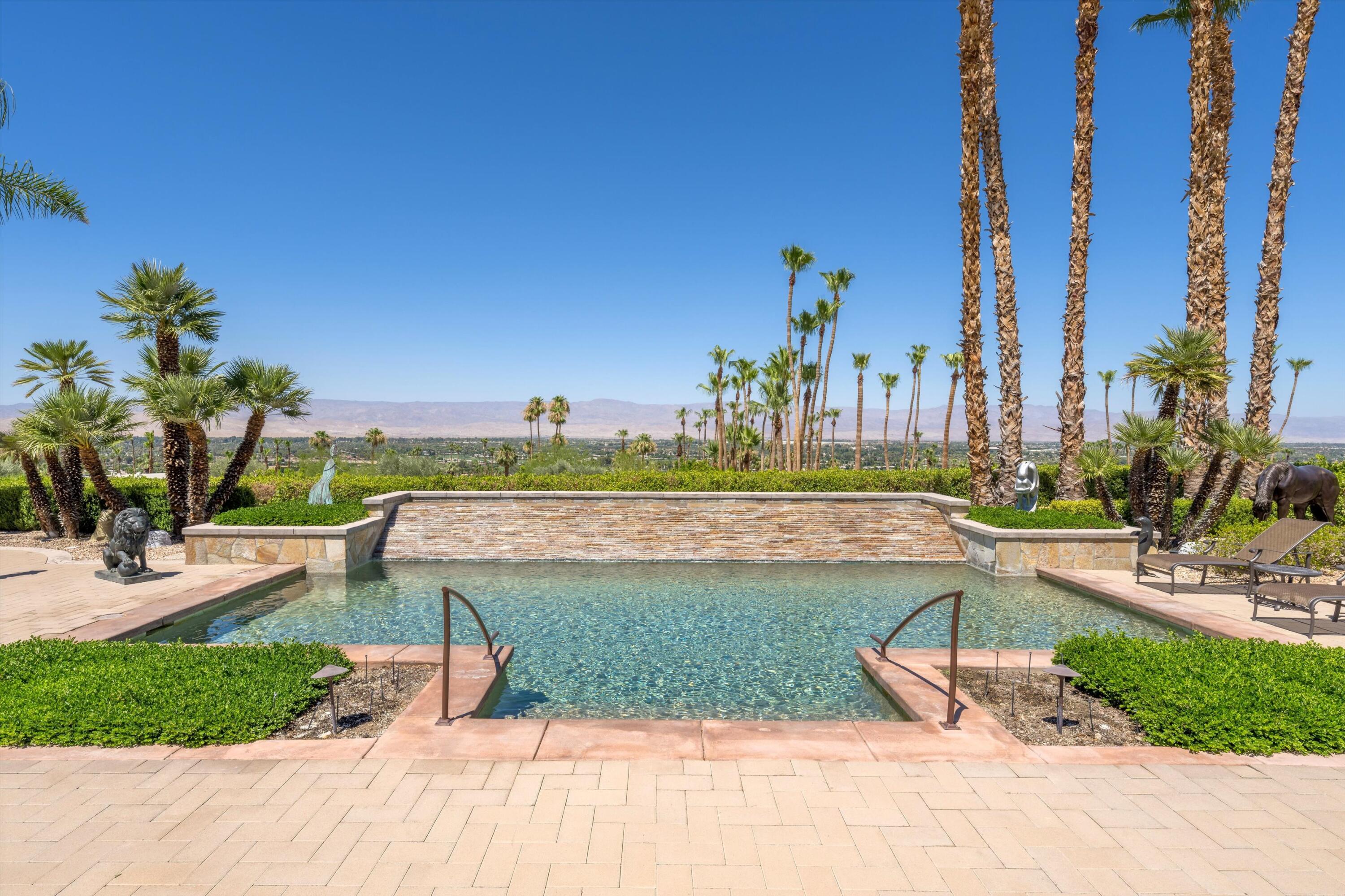 70150 Thunderbird Road Rancho Mirage, CA 92270 - Photo 55 of 67 a view of a swimming pool with a lawn chairs and a fire pit