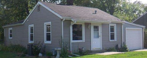 609 Barry Road Rockford, IL 61109 - Photo 1 of 14 a view of a house with brick walls and a yard with plants