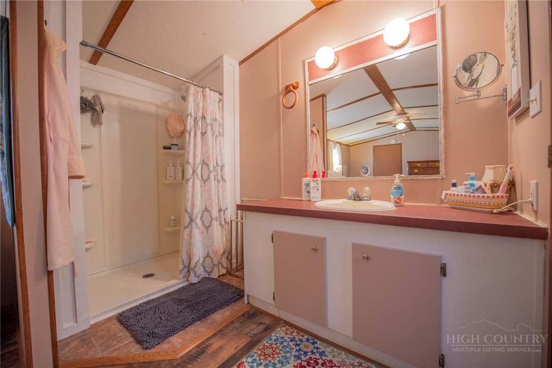 1848 West Mill Creek Road Warrensville, NC 28693 - Photo 32 of 50 a bathroom with a sink a mirror and a shower