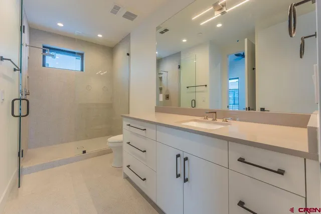 a bathroom with a shower sink and mirror