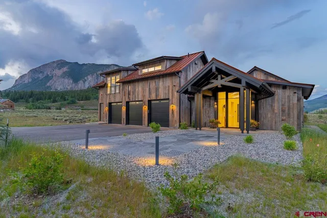 a view of a house with a yard and a large tree