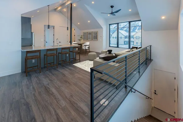 a living room with furniture a refrigerator and a kitchen view