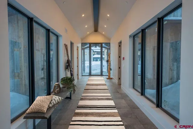 a view of a hallway with wooden floor and windows