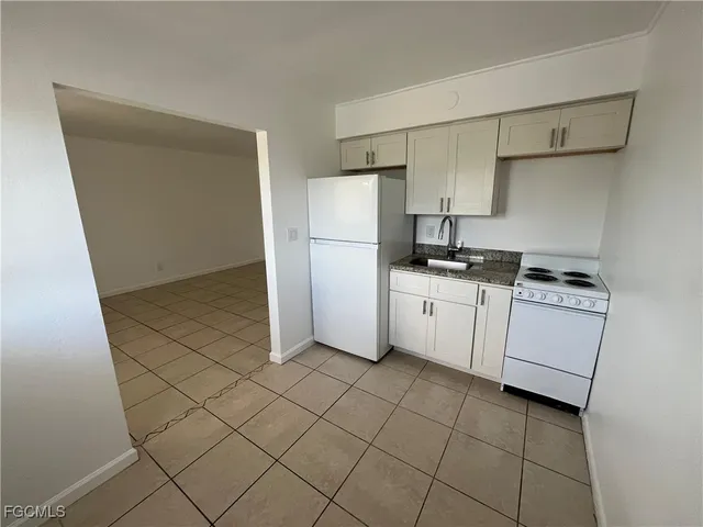 a kitchen with a stove a sink and a refrigerator