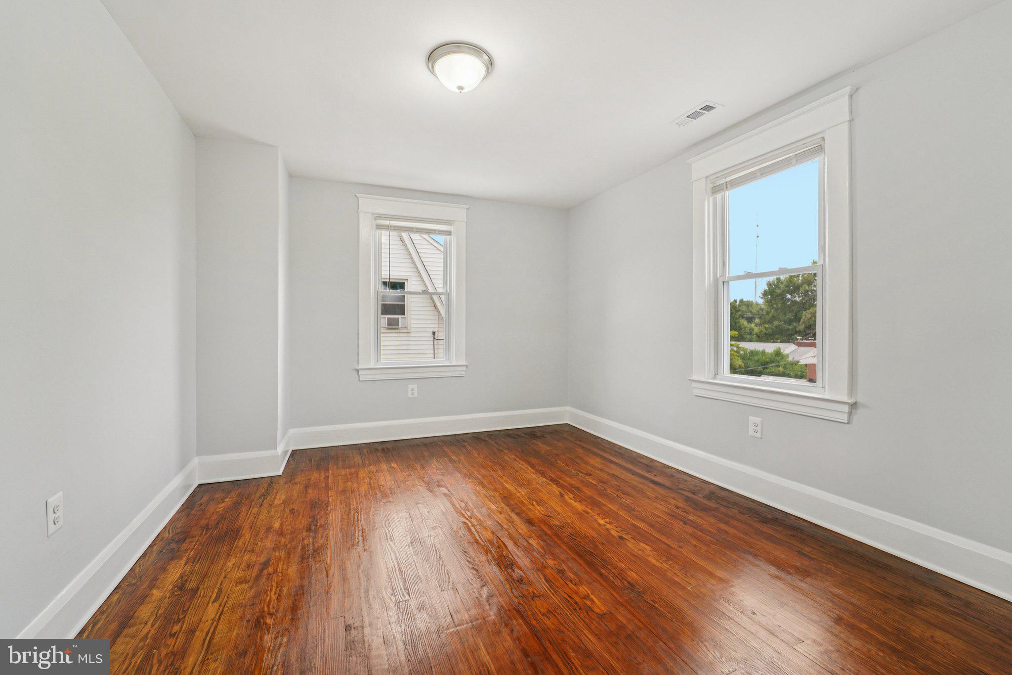 3030 Dunleer Road Dundalk, MD 21222 - Photo 18 of 26 an empty room with wooden floor and windows