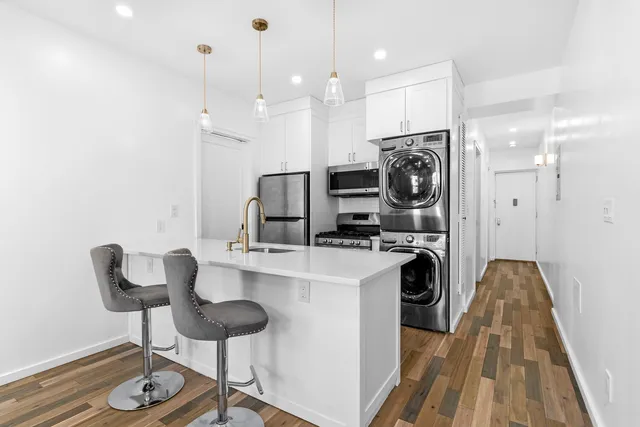 a kitchen with refrigerator and chairs