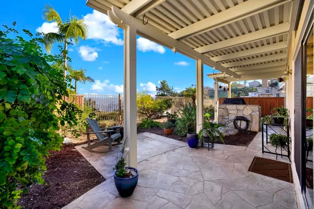 a view of a patio with a table and chairs under an umbrella