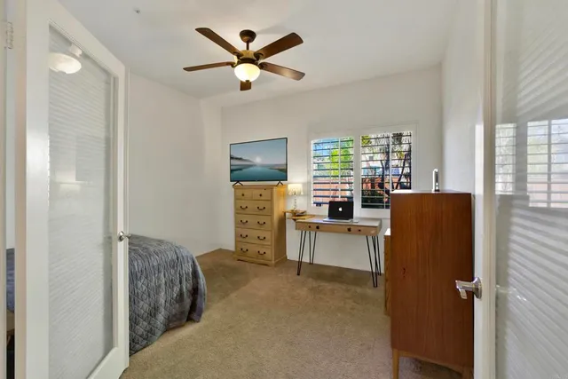 a bedroom with a bed and ceiling fan