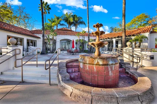 a view of swimming pool with lounge chair and palm trees