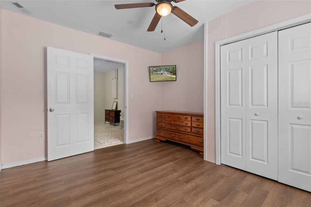 4325 South Canton Terrace Inverness, FL 34452 - Photo 16 of 35 a view of an empty room with wooden floor and a ceiling fan