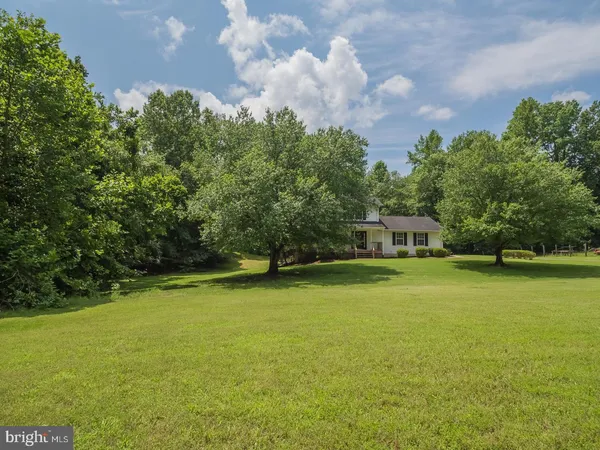 a front view of a house with a yard and trees