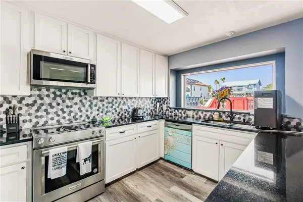 a kitchen with stainless steel appliances a sink stove top oven and microwave
