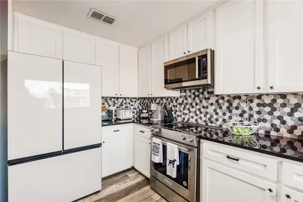 a kitchen with granite countertop cabinets and steel stainless steel appliances
