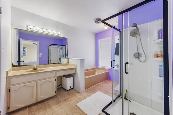 a spacious bathroom with a tub sink and mirror