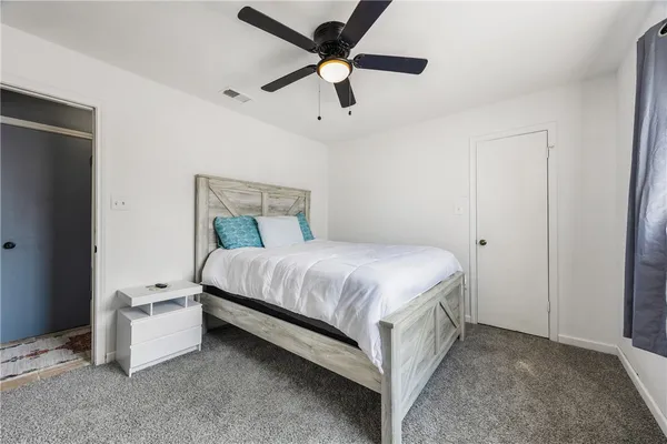 a bed room with a bed and a ceiling fan
