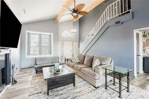 a living room with furniture a flat screen tv and a fireplace