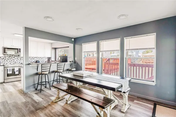 a dining room with furniture and large windows