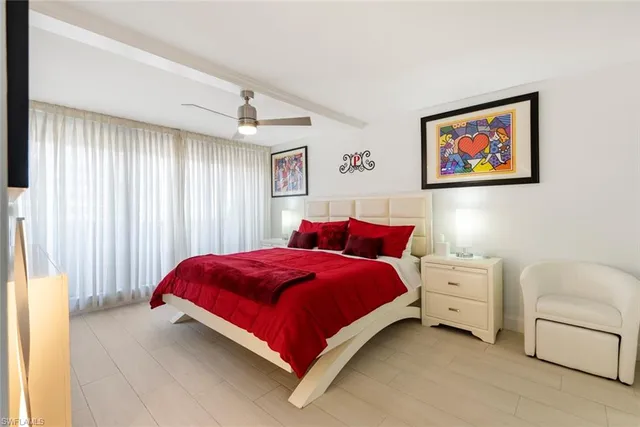 a bedroom with a large bed and a flat screen tv