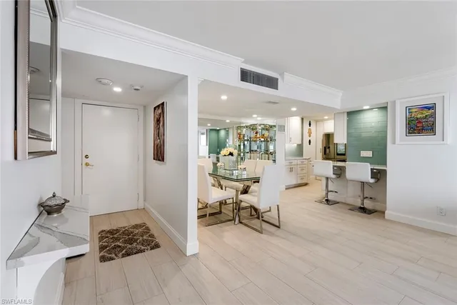 a kitchen with a stove a refrigerator and chairs