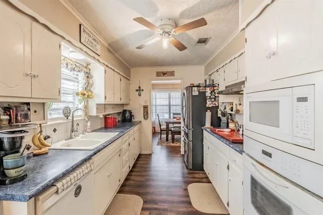 a large kitchen with lots of counter space and wooden floor