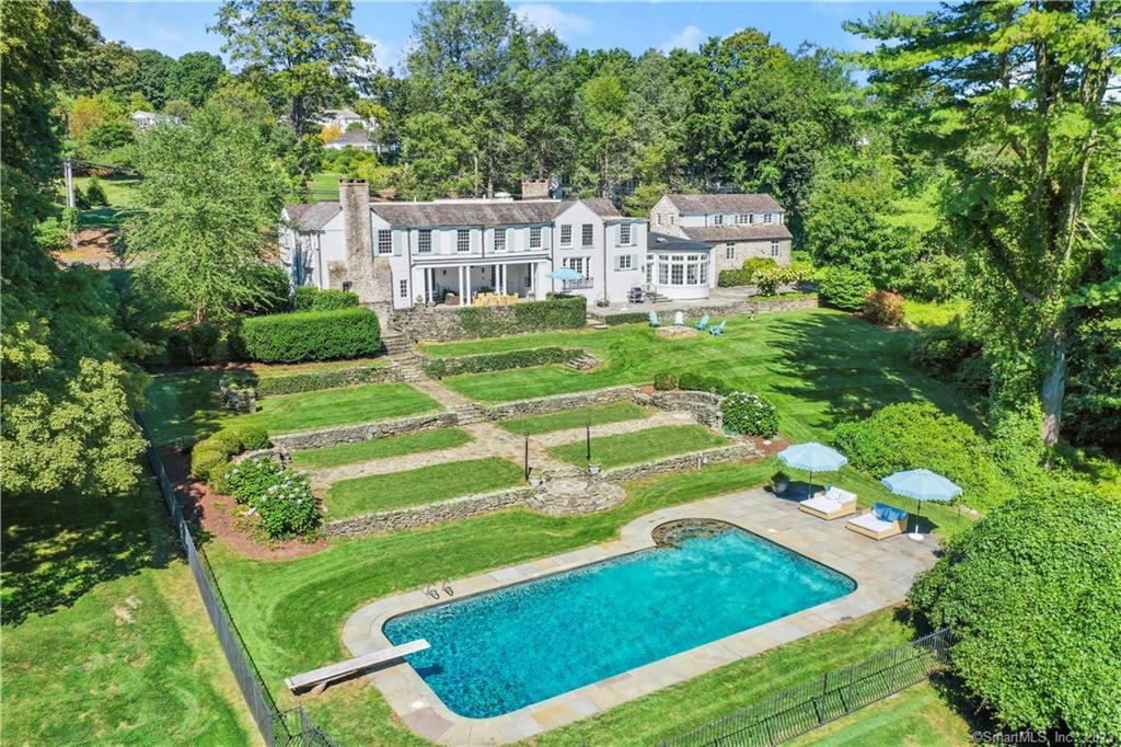 745 Old Academy Road Fairfield, CT 06824 - Photo 1 of 1 a view of a white house in a big yard with plants and large trees