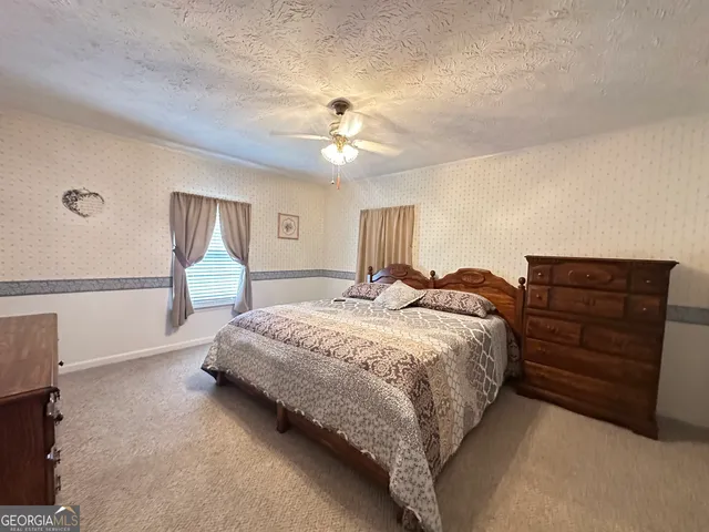 a spacious bedroom with a bed and a ceiling fan